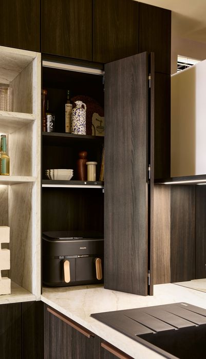 Moderne Küche mit Holzschränken, offenem Regal und einem geschlossenen Schrank, der Küchenutensilien und Flaschen zeigt.